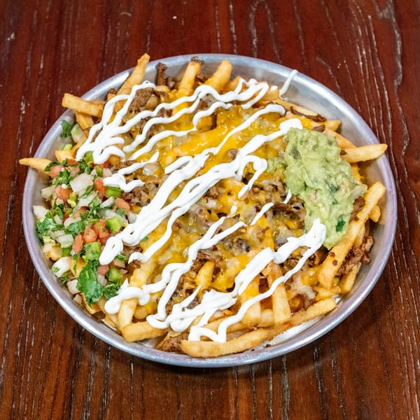 Loaded fries with melted cheese, ground meat, sour cream, guacamole, and pico de gallo.